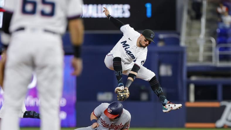 Sep 25, 2022; Miami, Florida, USA; Washington Nationals right fielder Lane Thomas (28) steals second base as Miami Marlins shortstop Miguel Rojas (11) jumps and attempts to tag him out during the first inning at loanDepot Park. Mandatory Credit: Sam Navarro-USA TODAY Sports
