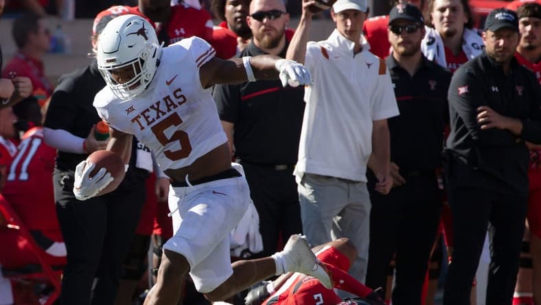 Texas' running back Bijan Robinson (5), left, runs with the ball against Texas Tech, Saturday, Sept. 24, 2022, at Jones AT&T Stadium. Texas Tech won, 37-34 in overtime.