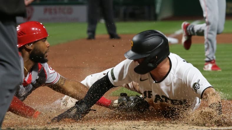 Sep 26, 2022; Pittsburgh, Pennsylvania, USA; Pittsburgh Pirates second baseman Kevin Newman (right) slides across home plate to score a run ahead of the tag by Cincinnati Reds catcher Chuckie Robinson (left) during the fifth inning at PNC Park. Mandatory Credit: Charles LeClaire-USA TODAY Sports