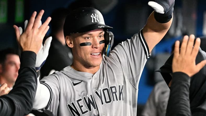 Sep 27, 2022; Toronto, Ontario, CAN;  New York Yankees center fielder Aaron Judge (99) celebrates in the dugout with team mates after scoring against the Toronto Blue Jays in the third inning at Rogers Centre. Mandatory Credit: Dan Hamilton-USA TODAY Sports