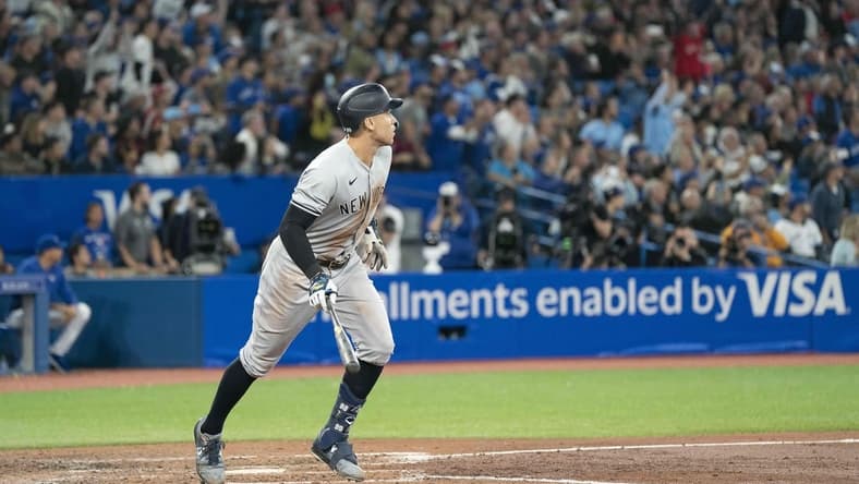 Sep 28, 2022; Toronto, Ontario, CAN; New York Yankees designated hitter Aaron Judge (99) hits his 61st home run scoring two runs against the Toronto Blue Jays during the seventh inning at Rogers Centre. Mandatory Credit: Nick Turchiaro-USA TODAY Sports