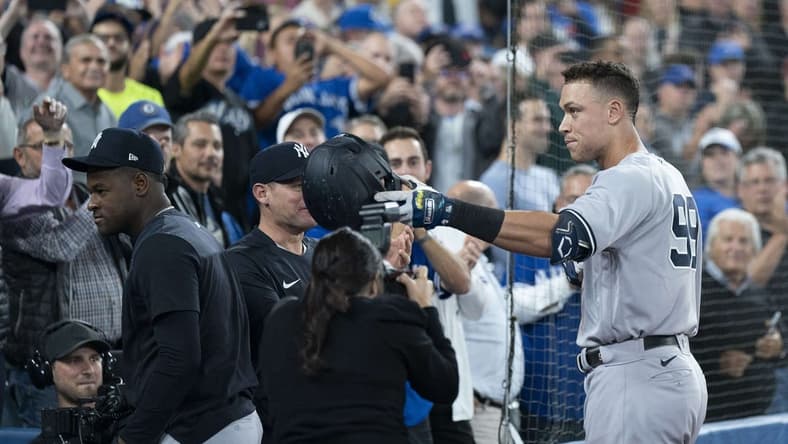 Sep 28, 2022; Toronto, Ontario, CAN; New York Yankees designated hitter Aaron Judge (99) tips his helmet towards his mother after hitting his 61st home run scoring two runs against the Toronto Blue Jays during the seventh inning at Rogers Centre. Mandatory Credit: Nick Turchiaro-USA TODAY Sports