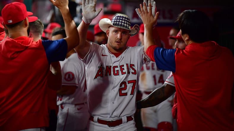 Sep 28, 2022; Anaheim, California, USA; Los Angeles Angels center fielder Mike Trout (27) is greeted after hitting a solo home run against the Oakland Athletics during the fourth inning at Angel Stadium. Mandatory Credit: Gary A. Vasquez-USA TODAY Sports