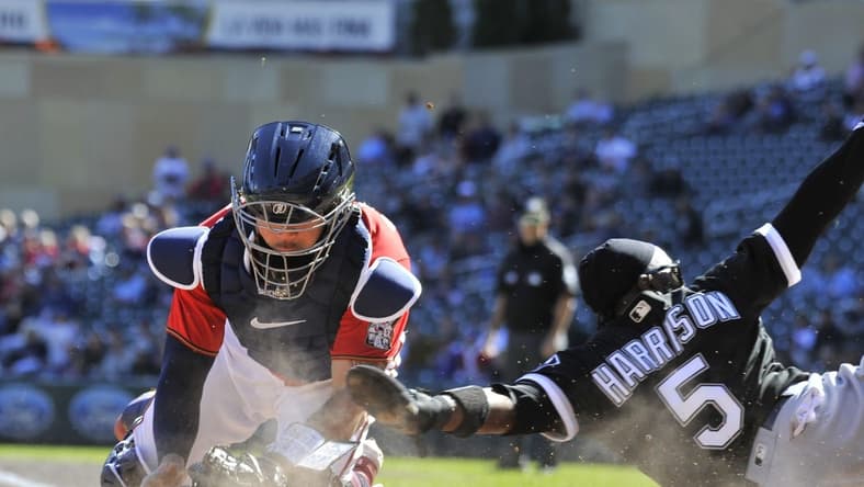 Sep 29, 2022; Minneapolis, Minnesota, USA; Chicago White Sox third baseman Josh Harrison (5) slides in safe at home plate as Minnesota Twins catcher Gary Sanchez (24) attempts to apply the tag during the third inning at Target Field. Mandatory Credit: Jeffrey Becker-USA TODAY Sports