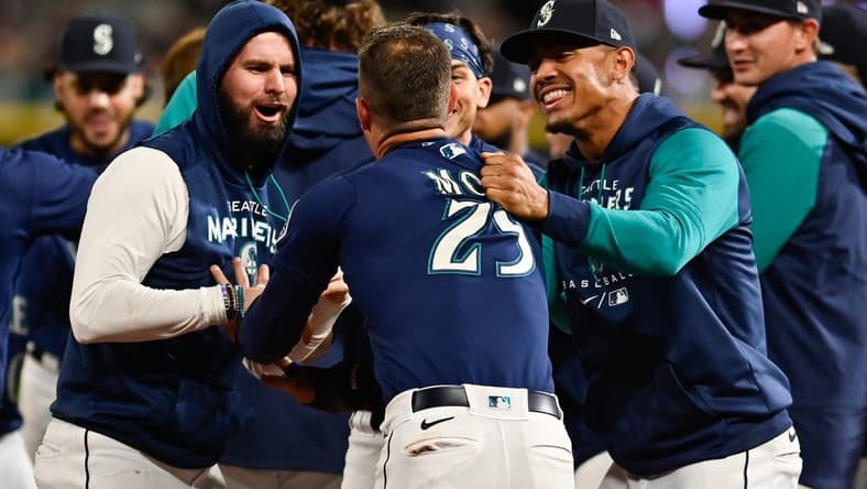 Sep 29, 2022; Seattle, Washington, USA; Seattle Mariners designated hitter Jesse Winker (27) and Julio Rodriguez celebrate with left fielder Dylan Moore (25) his run scored against the Texas Rangers during the eleventh inning at T-Mobile Park. Seattle defeated Texas 10-9. Mandatory Credit: Steven Bisig-USA TODAY Sports