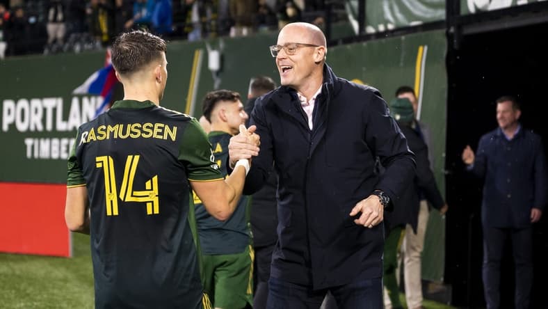 Mar 12, 2022; Portland, Oregon, USA; Portland Timbers defender Justin Rasmussen (14) celebrates with owner Merritt Paulson after a game against Austin FC at Providence Park. The Timbers won the game 1-0. Mandatory Credit: Troy Wayrynen-USA TODAY Sports