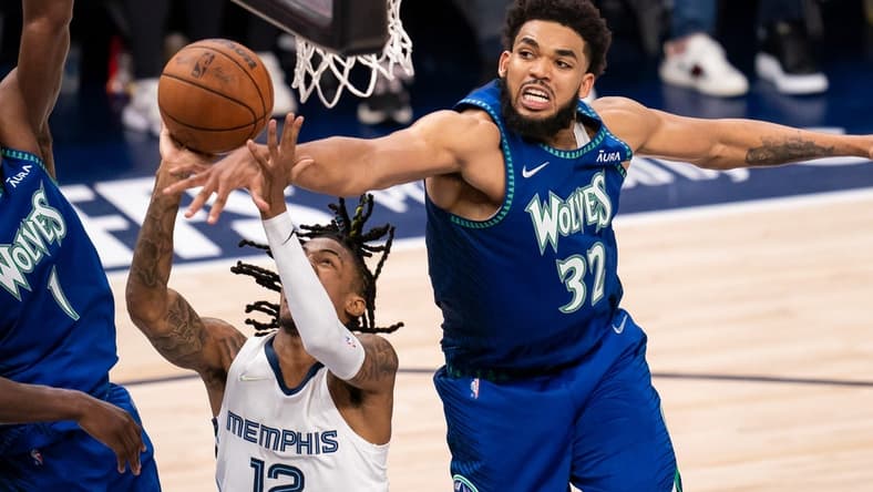 Apr 29, 2022; Minneapolis, Minnesota, USA; Minnesota Timberwolves center Karl-Anthony Towns (32) blocks Memphis Grizzlies guard Ja Morant (12) in the fourth quarter during game six of the first round for the 2022 NBA playoffs at Target Center. Mandatory Credit: Brad Rempel-USA TODAY Sports