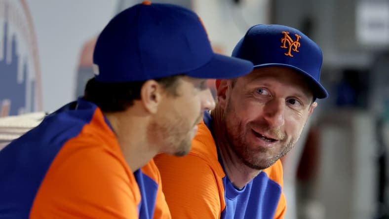 Aug 4, 2022; New York City, New York, USA; New York Mets starting pitchers Jacob deGrom (left) and Max Scherzer talk in the dugout during the ninth inning against the Atlanta Braves at Citi Field. Mandatory Credit: Brad Penner-USA TODAY Sports