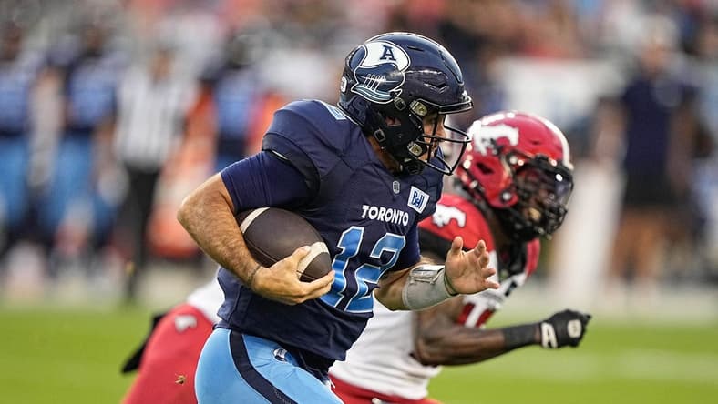 Aug 20, 2022; Toronto, Ontario, CAN; Toronto Argonauts quarterback Chad Kelly (12) and Calgary Stampeders defensive back Natrell Jamerson (16) at BMO Field. Mandatory Credit: John E. Sokolowski-USA TODAY Sports