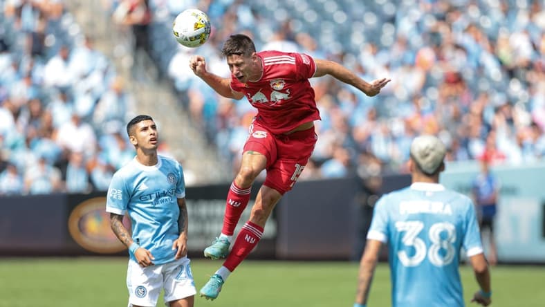 Sep 17, 2022; New York, New York, USA; New York Red Bulls defender Sean Nealis (15) heads the ball in front of New York City FC midfielder Santiago Rodriguez (20) during the first half at Yankee Stadium. Mandatory Credit: Vincent Carchietta-USA TODAY Sports