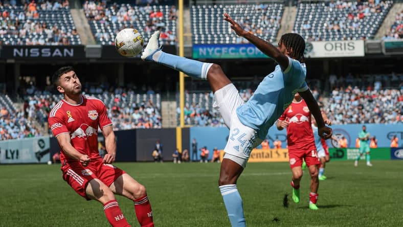 Sep 17, 2022; New York, New York, USA; New York City FC defender Tayvon Gray (24) kicks the ball against New York Red Bulls midfielder Lewis Morgan (10) at Yankee Stadium. Mandatory Credit: Vincent Carchietta-USA TODAY Sports
