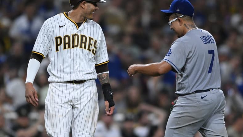 Sep 28, 2022; San Diego, California, USA; San Diego Padres third baseman Manny Machado (left) talks to Los Angeles Dodgers starting pitcher Julio Urias (7) at the end of the sixth inning at Petco Park. Mandatory Credit: Orlando Ramirez-USA TODAY Sports