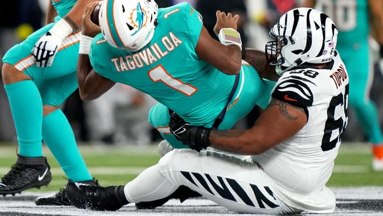 Sep 29, 2022; Cincinnati, Ohio, USA; Cincinnati Bengals defensive tackle Josh Tupou (68) sacks Miami Dolphins quarterback Tua Tagovailoa (1) in the second quarter at Paycor Stadium in Cincinnati. Tagovailoa sustained a head injury on the play and left the game for treatment. Mandatory Credit: Kareem Elgazzar-USA TODAY Sports