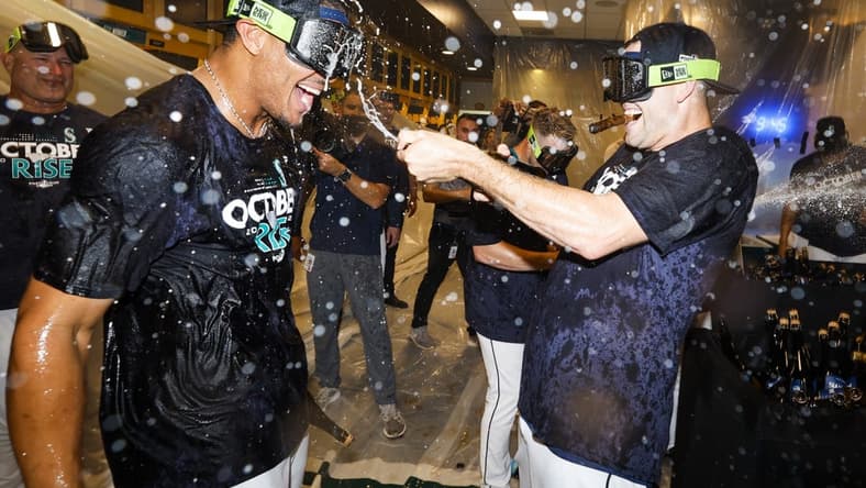 Sep 30, 2022; Seattle, Washington, USA; Seattle Mariners center fielder Julio Rodriguez (left) celebrates with relief pitcher Paul Sewald (right) in the clubhouse following a 2-1 victory against the Oakland Athletics to clinch a wild card appearance at T-Mobile Park. Mandatory Credit: Joe Nicholson-USA TODAY Sports