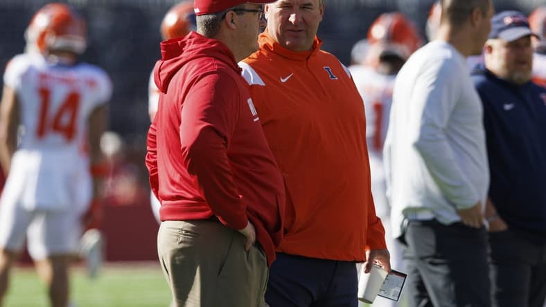 Oct 1, 2022; Madison, Wisconsin, USA;  Illinois Fighting Illini head coach Bret Bielema and Wisconsin Badgers head coach Paul Chryst talk on the field prior to the game at Camp Randall Stadium. Mandatory Credit: Jeff Hanisch-USA TODAY Sports