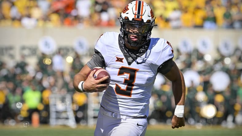 Oct 1, 2022; Waco, Texas, USA; Oklahoma State Cowboys quarterback Spencer Sanders (3) runs for a first down against the Baylor Bears during the first quarter at McLane Stadium. Mandatory Credit: Jerome Miron-USA TODAY Sports