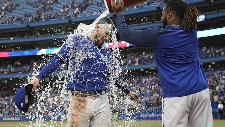 Oct 1, 2022; Toronto, Ontario, CAN; Toronto Blue Jays first baseman Vladimir Guerrero Jr., right, dumps a bucket of ice water over catcher Danny Jansen after a win over the Boston Red Sox at Rogers Centre. Mandatory Credit: John E. Sokolowski-USA TODAY Sports