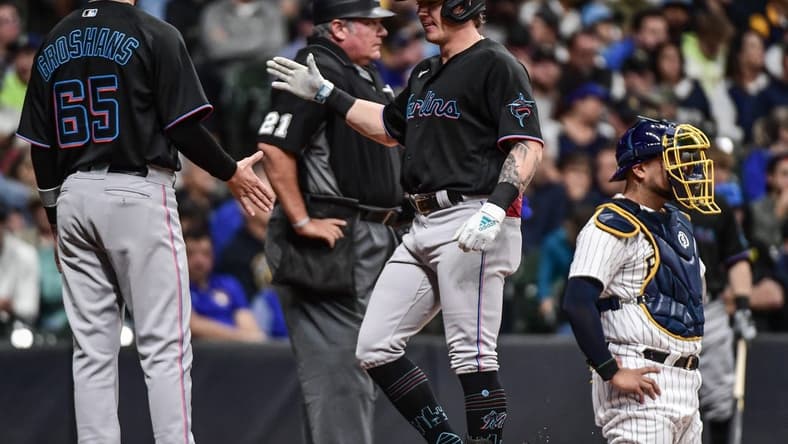 Oct 1, 2022; Milwaukee, Wisconsin, USA; Miami Marlins left fielder Peyton Burdick (86) is greeted by third baseman Jordan Groshans (65) after hitting a 2-run home run in the third inning as Milwaukee Brewers catcher Omar Narv ez (10) looks on at American Family Field. Mandatory Credit: Benny Sieu-USA TODAY Sports