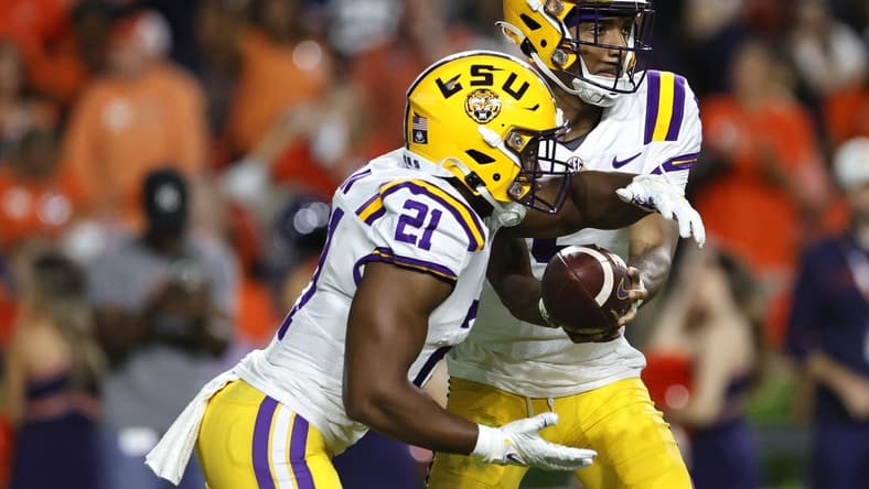 Oct 1, 2022; Auburn, Alabama, USA;  LSU Tigers quarterback Jayden Daniels (5) hands off to running back Noah Cain (21) during the third quarter against the Auburn Tigers at Jordan-Hare Stadium. Mandatory Credit: John Reed-USA TODAY Sports