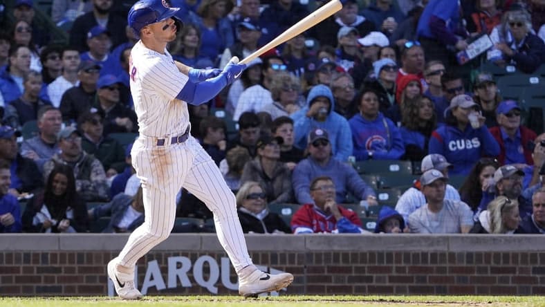 Oct 2, 2022; Chicago, Illinois, USA; Chicago Cubs shortstop Nico Hoerner (2) hits a sacrifice fly against the Cincinnati Reds during the fourth inning at Wrigley Field. Mandatory Credit: David Banks-USA TODAY Sports
