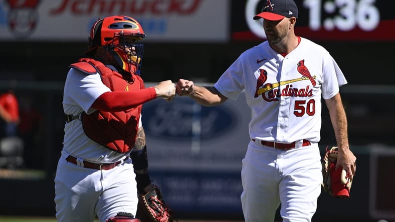 Oct 2, 2022; St. Louis, Missouri, USA; St. Louis Cardinals catcher Yadier Molina (4) and starting pitcher Adam Wainwright (50) fist bump as they walk in from the bullpen before their record breaking 328th career battery start in a game against the Pittsburgh Pirates at Busch Stadium. Mandatory Credit: Jeff Curry-USA TODAY Sports