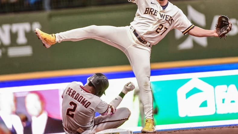 Oct 3, 2022; Milwaukee, Wisconsin, USA; Milwaukee Brewers shortstop Willy Adames (27) avoid Arizona Diamondbacks shortstop Geraldo Perdomo (2) after forcing him out in the third inning at American Family Field. Mandatory Credit: Benny Sieu-USA TODAY Sports