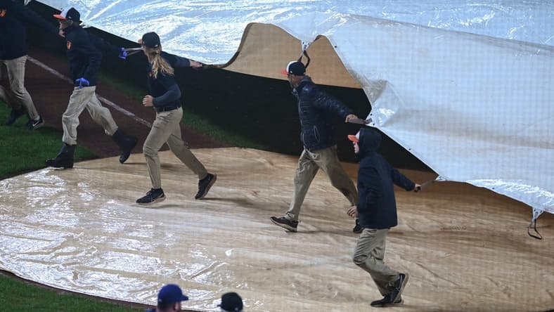 Oct 3, 2022; Baltimore, Maryland, USA; Members of the grounds crew pull a tarp over home plate during a rain delay during the eighth inning of the game between the Baltimore Orioles and the Toronto Blue Jays at Oriole Park at Camden Yards. Mandatory Credit: Tommy Gilligan-USA TODAY Sports