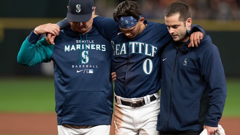 Oct 3, 2022; Seattle, Washington, USA; Seattle Mariners assistant athletic trainer Kevin Orloski and head coach Scott Servais help right fielder Sam Haggerty (0) off the field after Haggerty was injured sliding into second base during the ninth inning against the Detroit Tigers at T-Mobile Park. Detroit defeated Seattle 4-3. Mandatory Credit: Steven Bisig-USA TODAY Sports