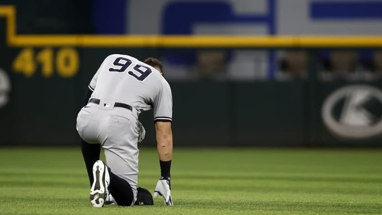 Oct 4, 2022; Arlington, Texas, USA; New York Yankees designated hitter Aaron Judge (99) kneels in the outfield before the game against the Texas Rangers at Globe Life Field. Mandatory Credit: Tim Heitman-USA TODAY Sports