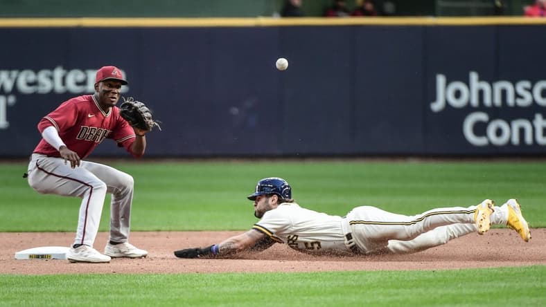 Oct 5, 2022; Milwaukee, Wisconsin, USA;  Milwaukee Brewers center fielder Garrett Mitchell (5) steals second base as Arizona Diamondbacks shortstop Geraldo Perdomo (2) waits for the ball in the second inning at American Family Field. Mandatory Credit: Benny Sieu-USA TODAY Sports