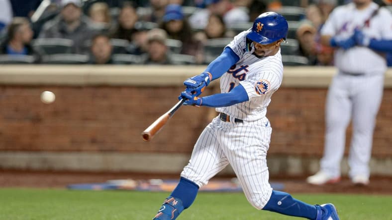 Oct 5, 2022; New York City, New York, USA; New York Mets shortstop Francisco Lindor (12) hits a three-RBI triple during the second inning against the Washington Nationals at Citi Field. Mandatory Credit: Vincent Carchietta-USA TODAY Sports
