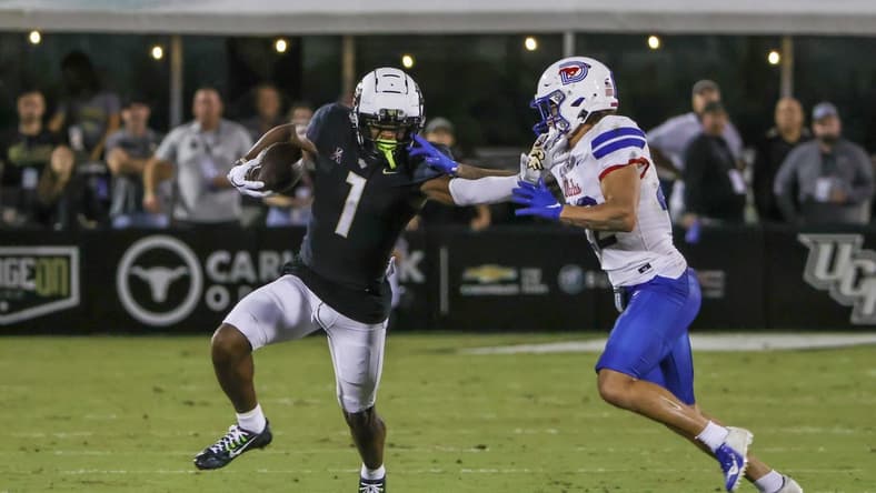 Oct 5, 2022; Orlando, Florida, USA; UCF Knights wide receiver Javon Baker (1) runs the ball against Southern Methodist Mustangs safety Nick Roberts (22) during the second half at FBC Mortgage Stadium. Mandatory Credit: Mike Watters-USA TODAY Sports