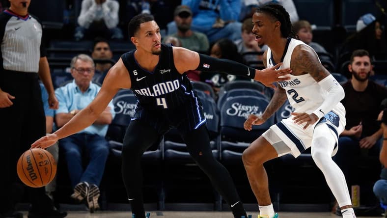 Oct 3, 2022; Memphis, Tennessee, USA; Orlando Magic guard Jalen Suggs (4) dribbles as Memphis Grizzlies guard Ja Morant (12) defends during the second half at FedExForum. Mandatory Credit: Petre Thomas-USA TODAY Sports