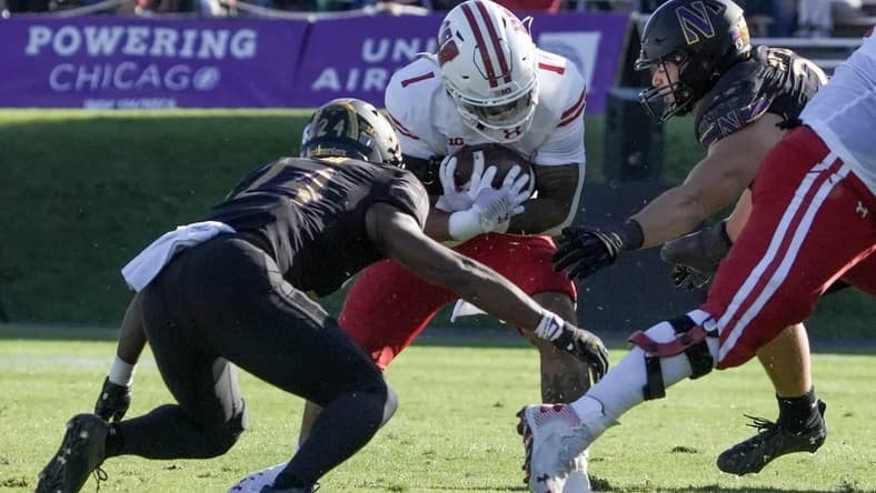 Wisconsin Badgers running back Chez Mellusi (1) is tackled by Northwestern Wildcats linebacker Xander Mueller (34) and Northwestern Wildcats defensive back Rod Heard II (24) during their game Saturday, Oct. 8, 2022, at Ryan Field in Evanston, Illinois.

Mjs Mjs 10082022 Uwfootball Badgers Ec267529