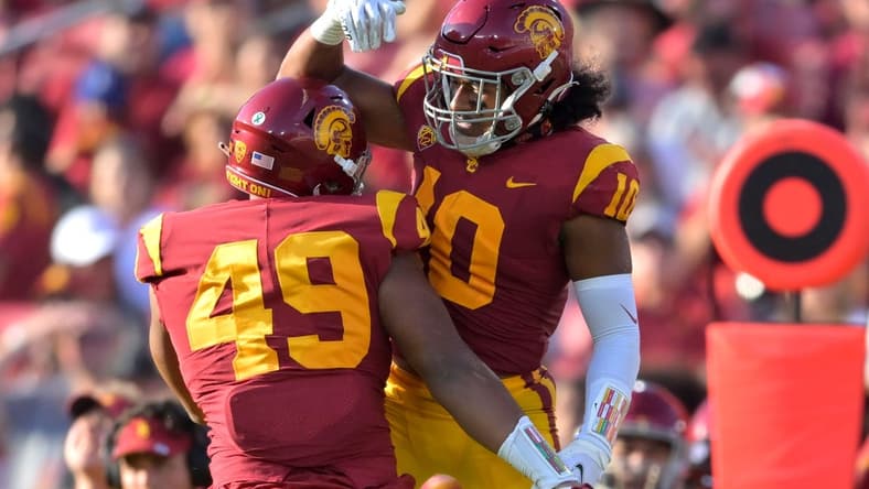 Oct 8, 2022; Los Angeles, California, USA; USC Trojans defensive lineman Tuli Tuipulotu (49) celebrates with Dlinebacker Ralen Goforth (10) after his second sack on Washington State Cougars quarterback Cameron Ward (1) in the first half at United Airlines Field at Los Angeles Memorial Coliseum. Mandatory Credit: Jayne Kamin-Oncea-USA TODAY Sports