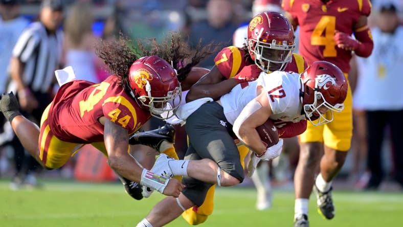 Oct 8, 2022; Los Angeles, California, USA;  Washington State Cougars wide receiver Robert Ferrel (12) drags USC Trojans linebacker Tuasivi Nomura (44) and defensive back Calen Bullock (7) into the end zone for a touchdown in the first half at United Airlines Field at Los Angeles Memorial Coliseum. Mandatory Credit: Jayne Kamin-Oncea-USA TODAY Sports