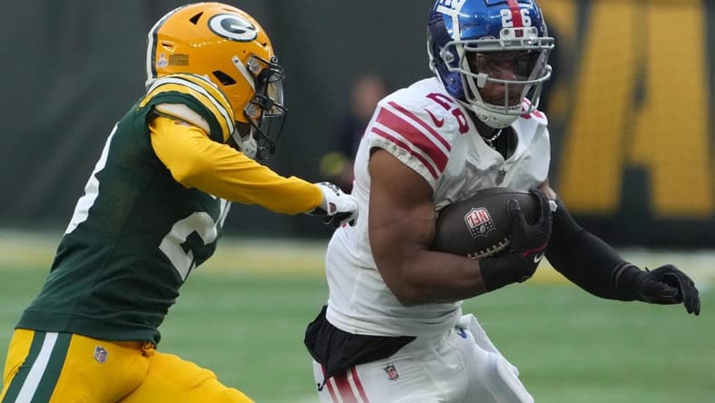 Oct 9, 2022; London, United Kingdom; New York Giants running back Saquon Barkley (26) carries the ball against Green Bay Packers cornerback Jaire Alexander (23) in the first half during an NFL International Series game at Tottenham Hotspur Stadium. Mandatory Credit: Kirby Lee-USA TODAY Sports