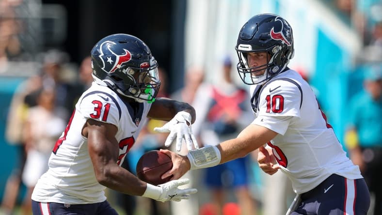 Oct 9, 2022; Jacksonville, Florida, USA;  Houston Texans quarterback Davis Mills (10) hands off to Houston Texans running back Dameon Pierce (31) against the Jacksonville Jaguars in the first quarter at TIAA Bank Field. Mandatory Credit: Nathan Ray Seebeck-USA TODAY Sports