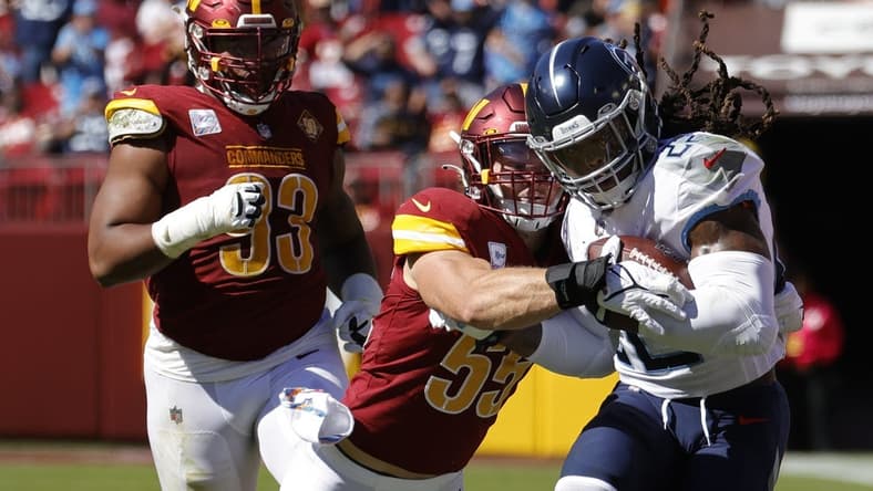Oct 9, 2022; Landover, Maryland, USA; Tennessee Titans running back Derrick Henry (22) carries the ball as Washington Commanders linebacker Cole Holcomb (55) makes the tackle during the first quarter at FedExField. Mandatory Credit: Geoff Burke-USA TODAY Sports
