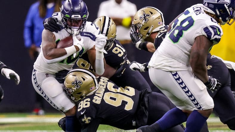 Oct 9, 2022; New Orleans, Louisiana, USA; Seattle Seahawks running back Rashaad Penny (20) is tackled by New Orleans Saints defensive end Carl Granderson (96) and defensive tackle Kentavius Street (91) during the first half at Caesars Superdome. Mandatory Credit: Stephen Lew-USA TODAY Sports
