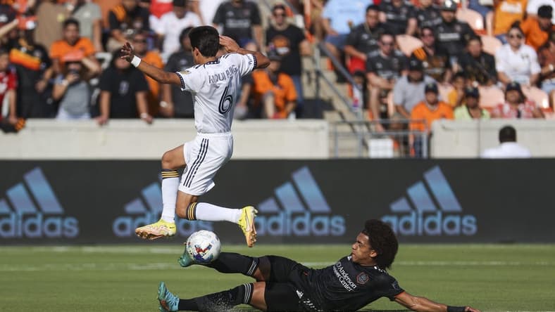 Oct 9, 2022; Houston, Texas, USA; Houston Dynamo FC midfielder Adalberto Carrasquilla (20) attempts to get control of the ball from LA Galaxy midfielder Riqui Puig (6) during the first half at PNC Stadium. Mandatory Credit: Troy Taormina-USA TODAY Sports