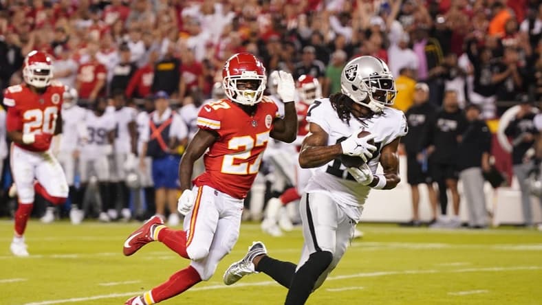 Oct 10, 2022; Kansas City, Missouri, USA; Las Vegas Raiders wide receiver Davante Adams (17) runs the ball in for a touchdown pursued by Kansas City Chiefs cornerback Rashad Fenton (27) in the first half at GEHA Field at Arrowhead Stadium. Mandatory Credit: Jay Biggerstaff-USA TODAY Sports