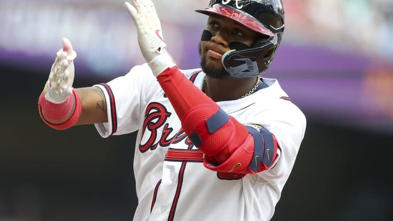 Oct 11, 2022; Atlanta, Georgia, USA; Atlanta Braves right fielder Ronald Acuna Jr. (13) reacts at first base after he singles against the Philadelphia Phillies in the fourth inning during game one of the NLDS for the 2022 MLB Playoffs at Truist Park. Mandatory Credit: Brett Davis-USA TODAY Sports