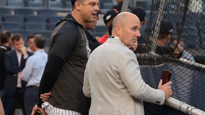 Oct 11, 2022; Bronx, New York, USA; New York Yankees manager Aaron Boone, left, and general manager Brian Cashman watch batting practice before game one of the ALDS against the Cleveland Guardians for the 2022 MLB Playoffs at Yankee Stadium. Mandatory Credit: Vincent Carchietta-USA TODAY Sports