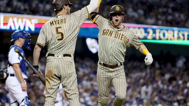 Oct 12, 2022; Los Angeles, California, USA; San Diego Padres second baseman Jake Cronenworth (9) celebrates with right fielder Wil Myers (5) after hitting a home run in the eighth inning of game two of the NLDS for the 2022 MLB Playoffs against the Los Angeles Dodgers at Dodger Stadium. Mandatory Credit: Kiyoshi Mio-USA TODAY Sports