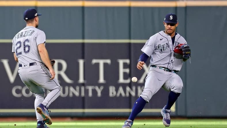 Oct 13, 2022; Houston, Texas, USA; Seattle Mariners second baseman Adam Frazier (26) and center fielder Julio Rodriguez (right) are unable to catch a single hit by Houston Astros shortstop Jeremy Pena (not pictured) during the sixth inning of game two of the ALDS for the 2022 MLB Playoffs at Minute Maid Park. Mandatory Credit: Troy Taormina-USA TODAY Sports