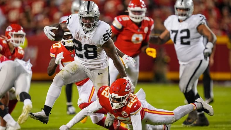 Oct 10, 2022; Kansas City, Missouri, USA; Las Vegas Raiders running back Josh Jacobs (28) runs the ball against Kansas City Chiefs safety Juan Thornhill (22) during the second half at GEHA Field at Arrowhead Stadium. Mandatory Credit: Jay Biggerstaff-USA TODAY Sports
