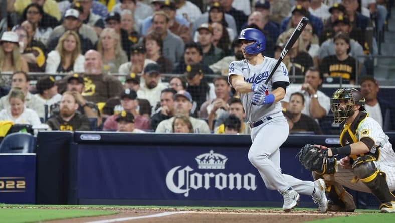 Oct 14, 2022; San Diego, California, USA; Los Angeles Dodgers catcher Austin Barnes (15) hits a double in the fifth inning against the San Diego Padres during game three of the NLDS for the 2022 MLB Playoffs at Petco Park. Mandatory Credit: Kiyoshi Mio-USA TODAY Sports