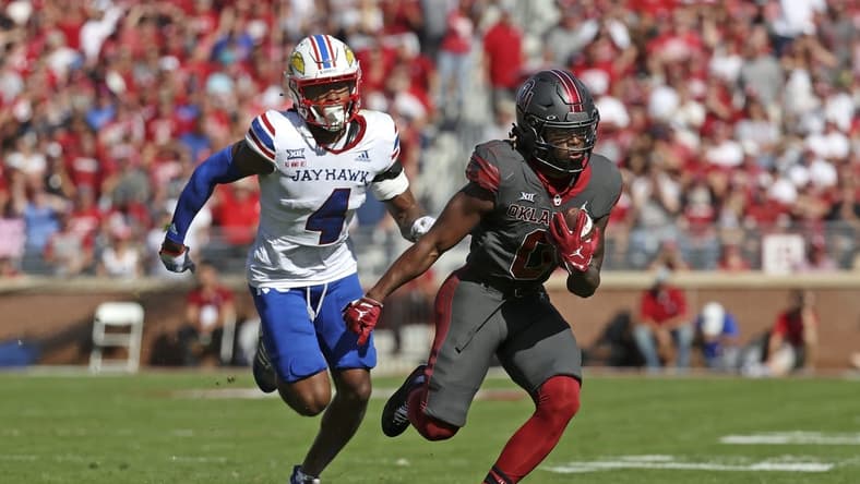Oct 15, 2022; Norman, Oklahoma, USA;  Oklahoma Sooners running back Eric Gray (0) runs with the ball as Kansas Jayhawks safety Marvin Grant (4) chases during the first half at Gaylord Family-Oklahoma Memorial Stadium. Mandatory Credit: Kevin Jairaj-USA TODAY Sports