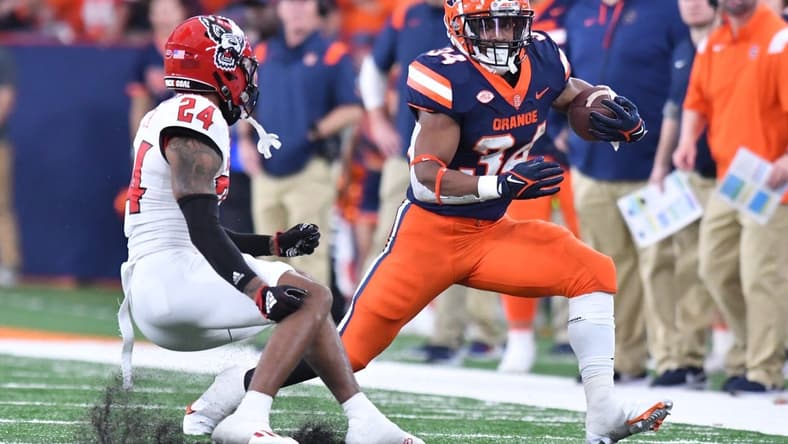 Oct 15, 2022; Syracuse, New York, USA; Syracuse Orange running back Sean Tucker (34) tries to move past North Carolina State Wolfpack cornerback Derrek Pitts Jr. (24) in the second quarter at JMA Wireless Dome. Mandatory Credit: Mark Konezny-USA TODAY Sports